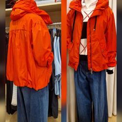 Schneiderpuppe mit orangefarbener Kapuzenjacke, Strickpullover und weiter Jeans