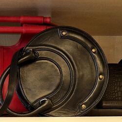 Rote und schwarze Taschen auf einem Regal