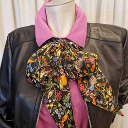 schwarze Lederjacke, pinke Bluse, gebundener Schal mit Tier- und Blumenmuster